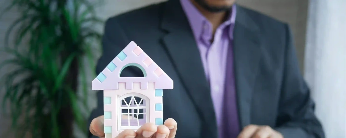 Wealth Tax in Colombia 2026: Who Has to Pay It (And Why the Number You've Seen Might Be Wrong) Wealth tax Colombia 2026 - foreign property owner holding a house model, reviewing net worth threshold with a tax advisor