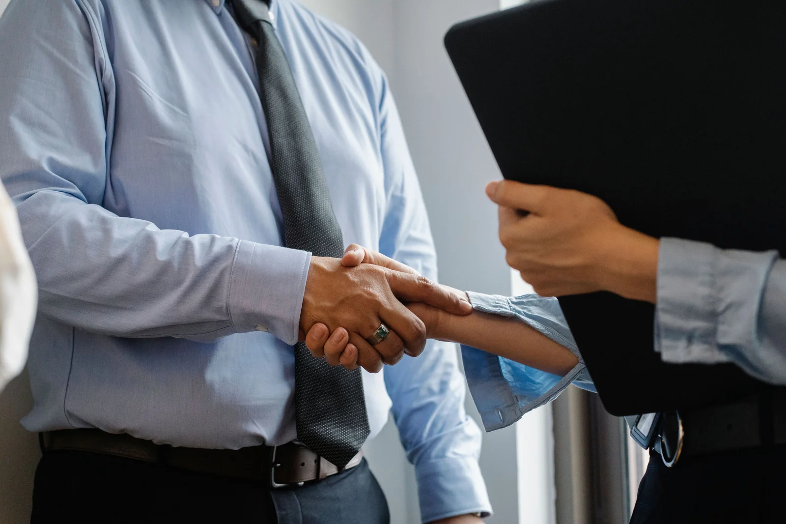 Employer and employee shaking hands after signing a written employment contract in Colombia