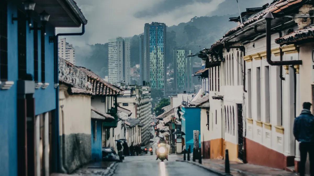 La Candelaria street in Bogotá with the city skyline behind